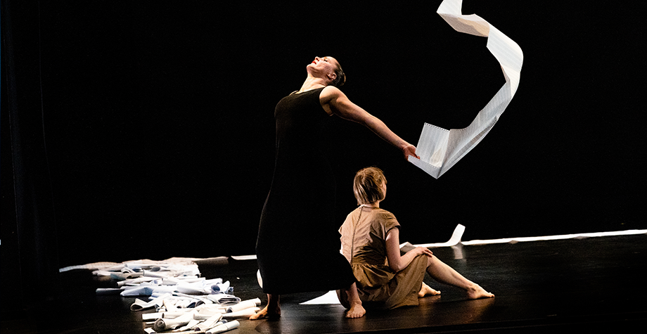 Two dancers with paper on stage